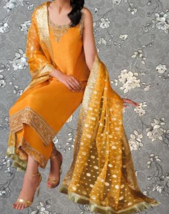 A woman wearing a bright yellow dress with a matching shawl is sitting against a gray floral background.