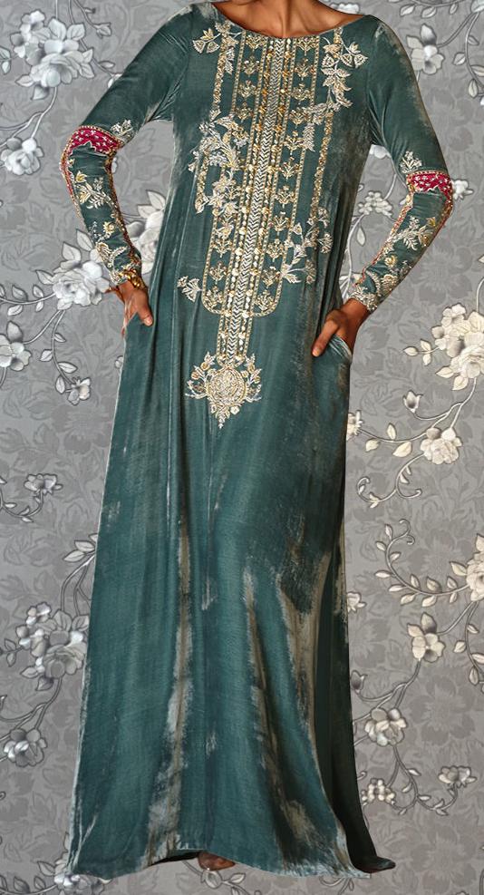 A woman wearing a long, green dress with intricate gold embroidery and floral patterns.