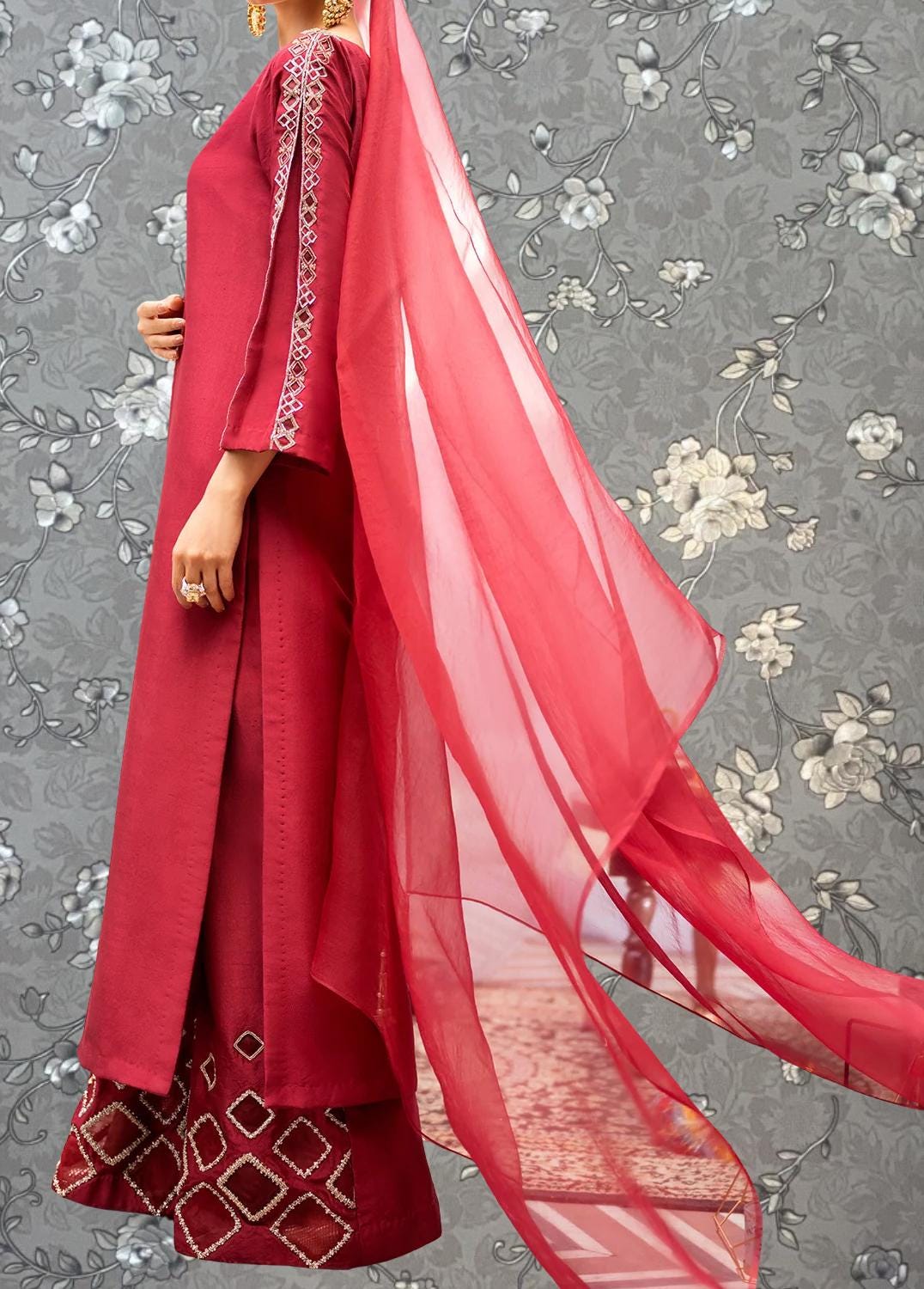 A woman wearing a red dress with a long, flowing skirt and a matching red shawl.