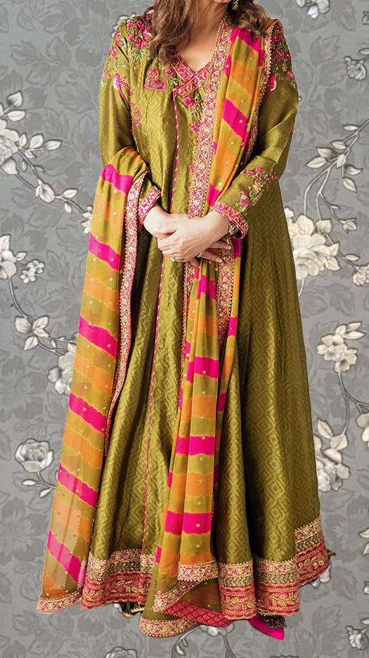 A woman wearing a long, green dress with a colorful, patterned shawl draped over her shoulders.