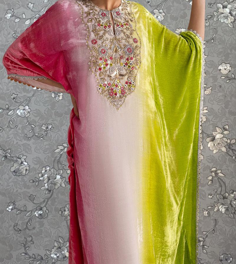 A woman wearing a colorful, patterned dress with a pink and green gradient.