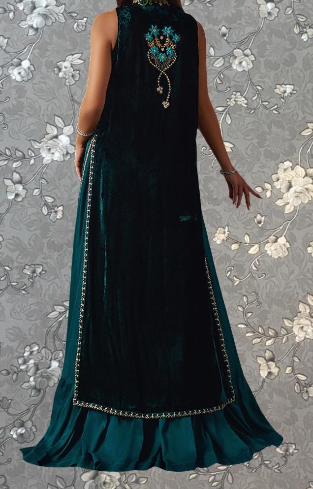 A woman wearing a long, green velvet dress with a floral pattern on the back.