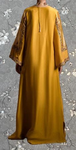 a long, yellow dress with intricate embroidery on the sleeves and hem.