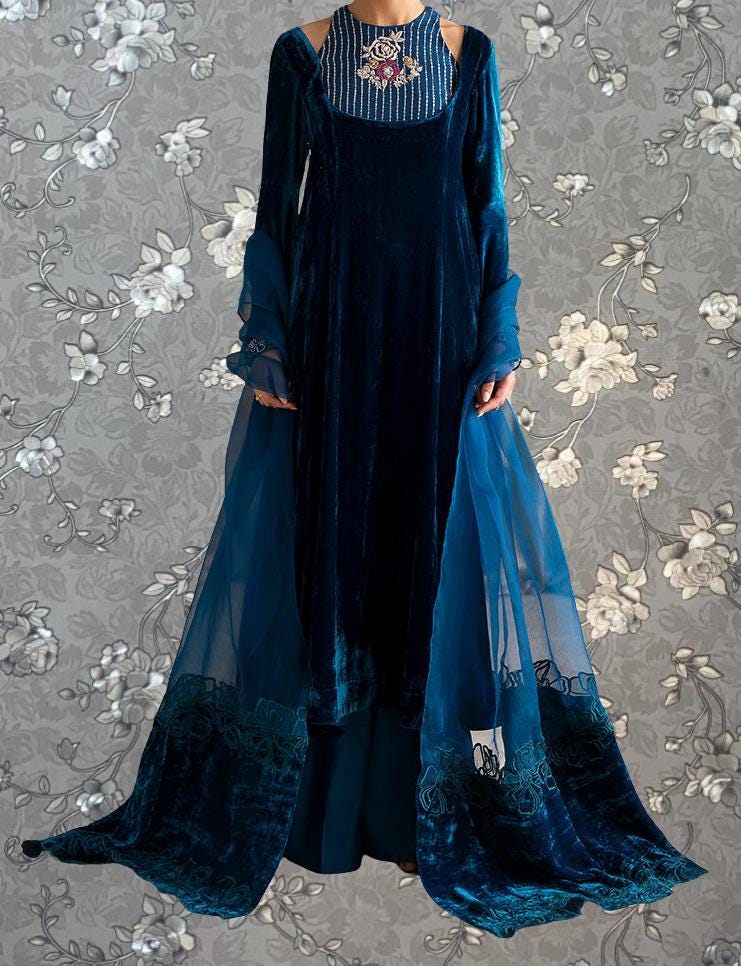 A long, blue velvet dress with a high neckline and long sleeves, featuring a sheer blue cape draped over the back.