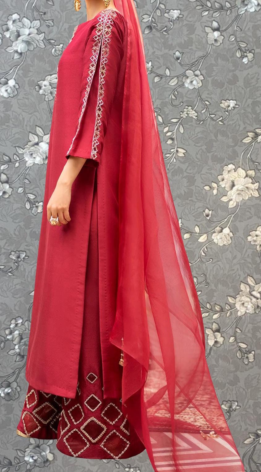 A person wearing a red dress with a long, flowing skirt and a matching red shawl.