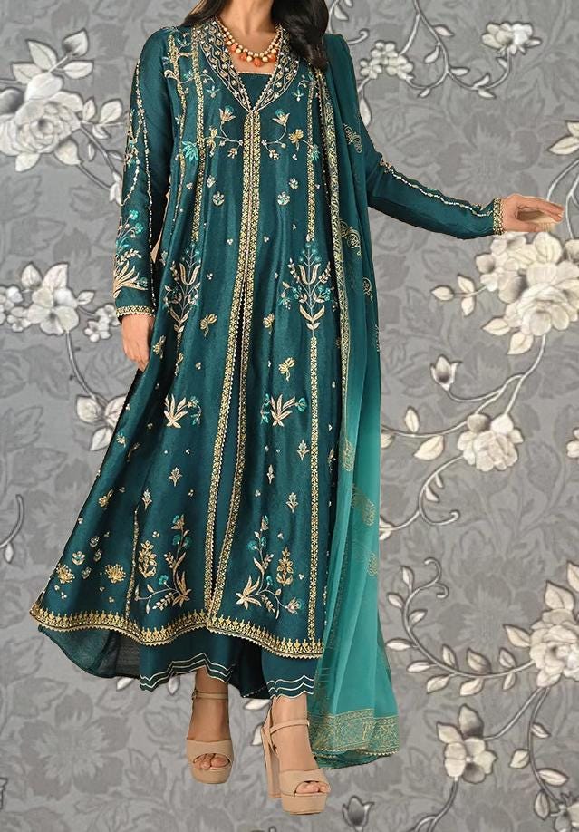 A woman wearing a long, green dress with gold embroidery and a matching green shawl.