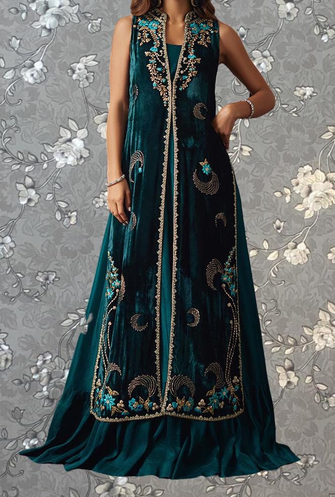 A woman wearing a long, sleeveless green velvet dress with intricate embroidered patterns.