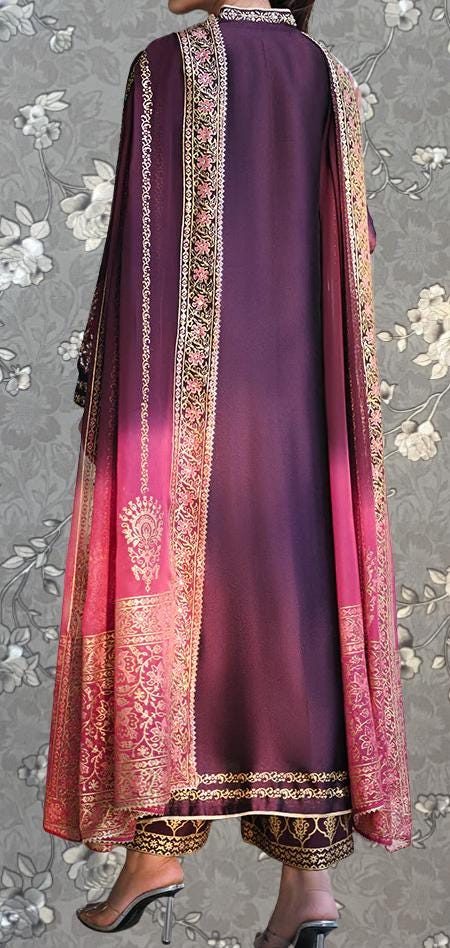 a person wearing a long, purple dress with a pink and gold patterned shawl draped over the shoulders. The dress has a high collar and long sleeves, giving it a formal and elegant appearance. The person is standing against a gray floral background, which complements the color of the dress.