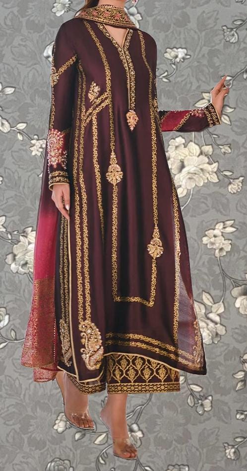 A woman wearing a long, burgundy dress with gold embroidery and a matching red shawl.
