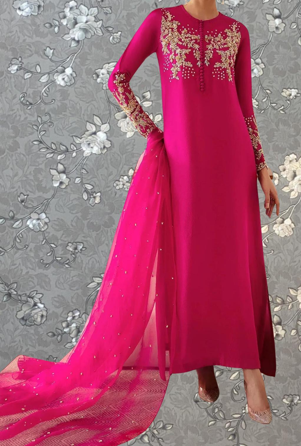 A woman wearing a long, pink dress with gold embroidery and a matching pink shawl.