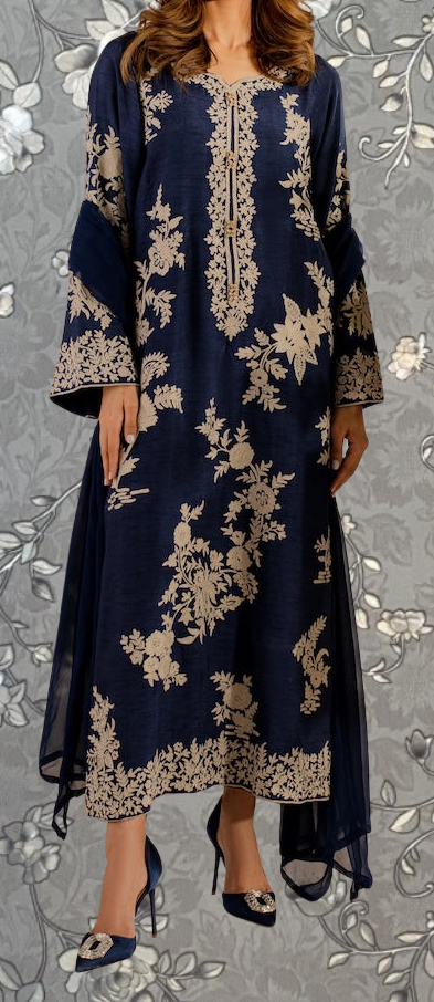 A woman wearing a long navy blue dress with gold embroidered patterns and high heels.
