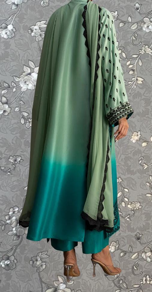a person wearing a long, green and black patterned dress with a matching green and black shawl draped over their shoulders.