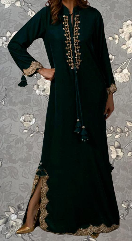 A woman wearing a long, dark green dress with gold embroidery and tassels on the sleeves.