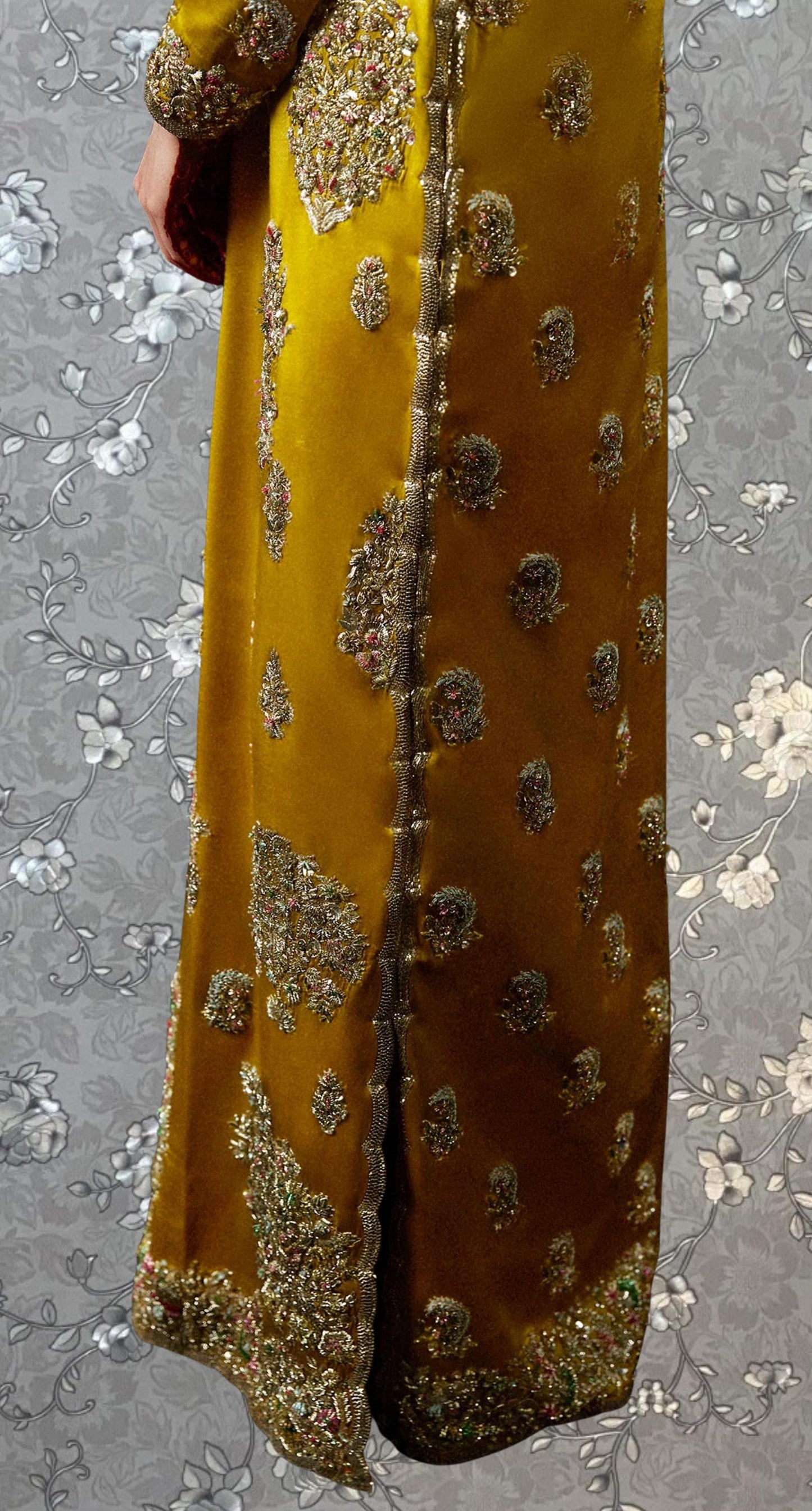 a close-up view of a gold and yellow dress with intricate embroidery and patterns.