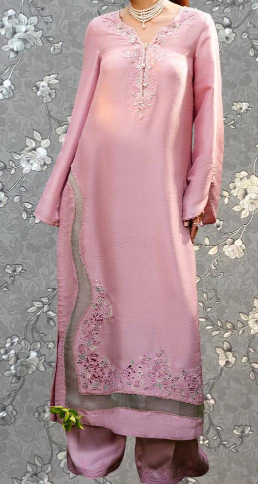 A woman wearing a long pink dress with intricate embroidery and floral patterns.