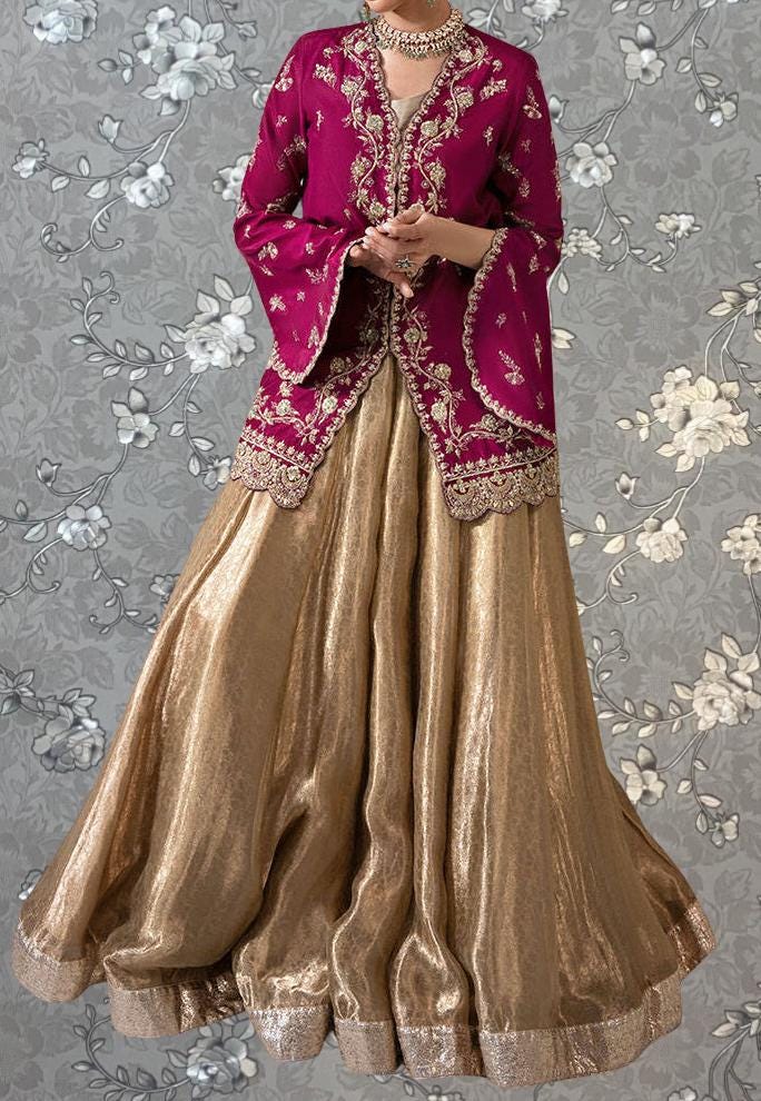 A woman wearing a long, gold and red dress with a high collar and sleeves, standing against a gray floral background.