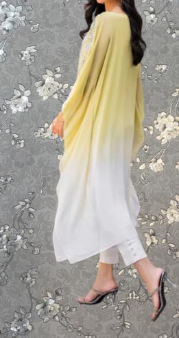 A woman wearing a yellow and white dress with a long, flowing skirt and high heels is standing against a gray floral background.