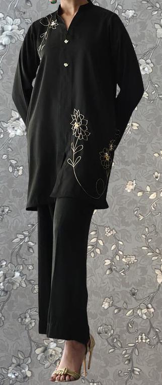 A person wearing a black outfit with gold embroidered designs on the front.