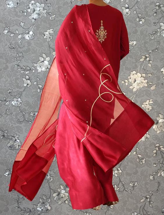A red dress with a floral pattern and a matching red shawl is shown against a gray floral background.