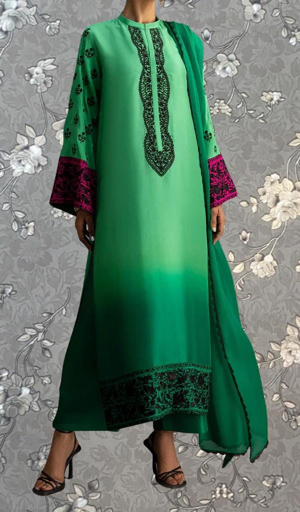 A person wearing a long green dress with pink accents and a matching green shawl.