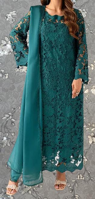 A woman wearing a long, green lace dress with a matching green shawl draped over her shoulders.