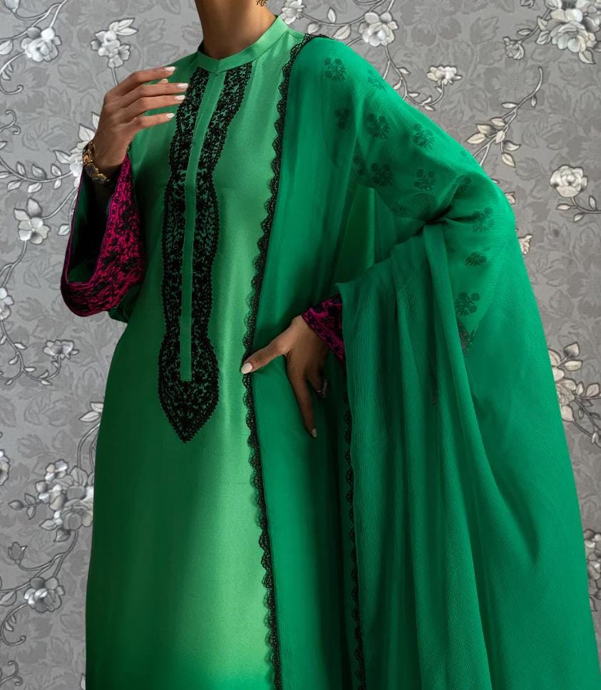 A person wearing a green dress with pink accents and a matching green shawl.