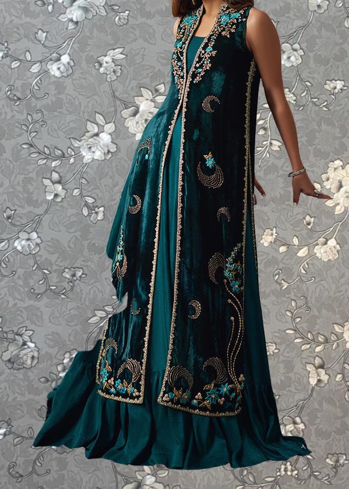 A woman wearing a long, green velvet dress with intricate gold embroidery and floral patterns.