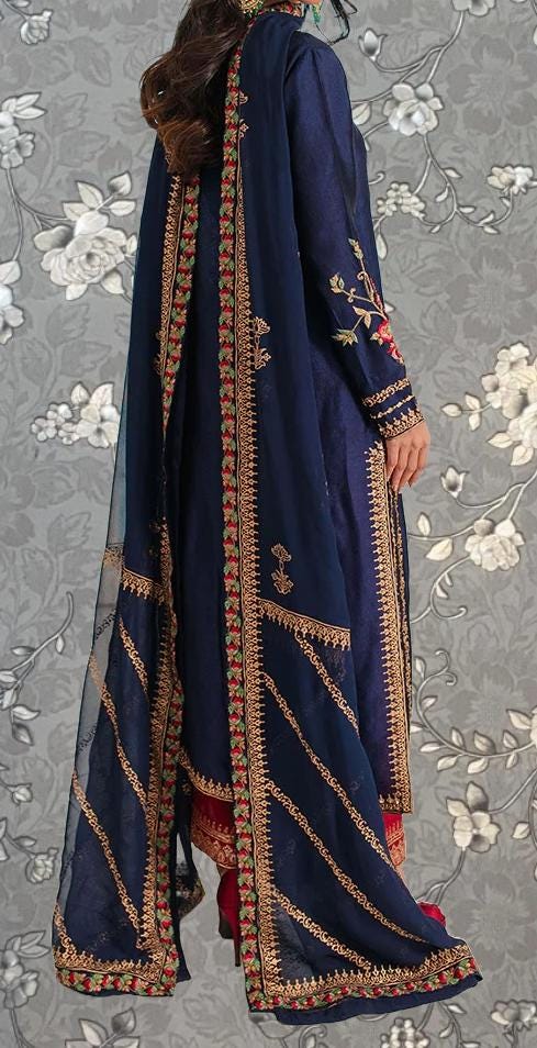 A woman wearing a long, navy blue dress with gold embroidery and a matching shawl.