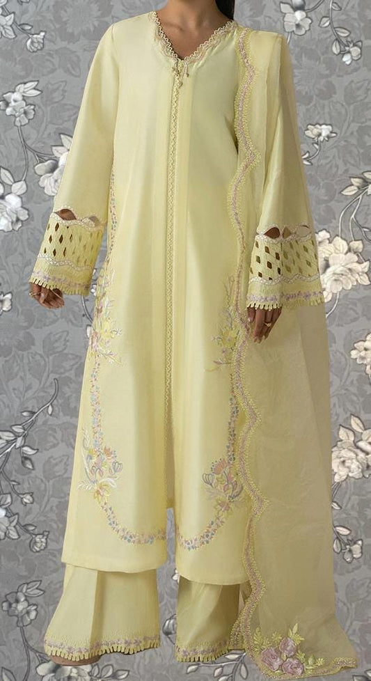A person wearing a long, yellow dress with intricate embroidery and lace details.