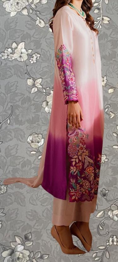 A woman wearing a long, flowing dress with a floral pattern in shades of pink and purple.
