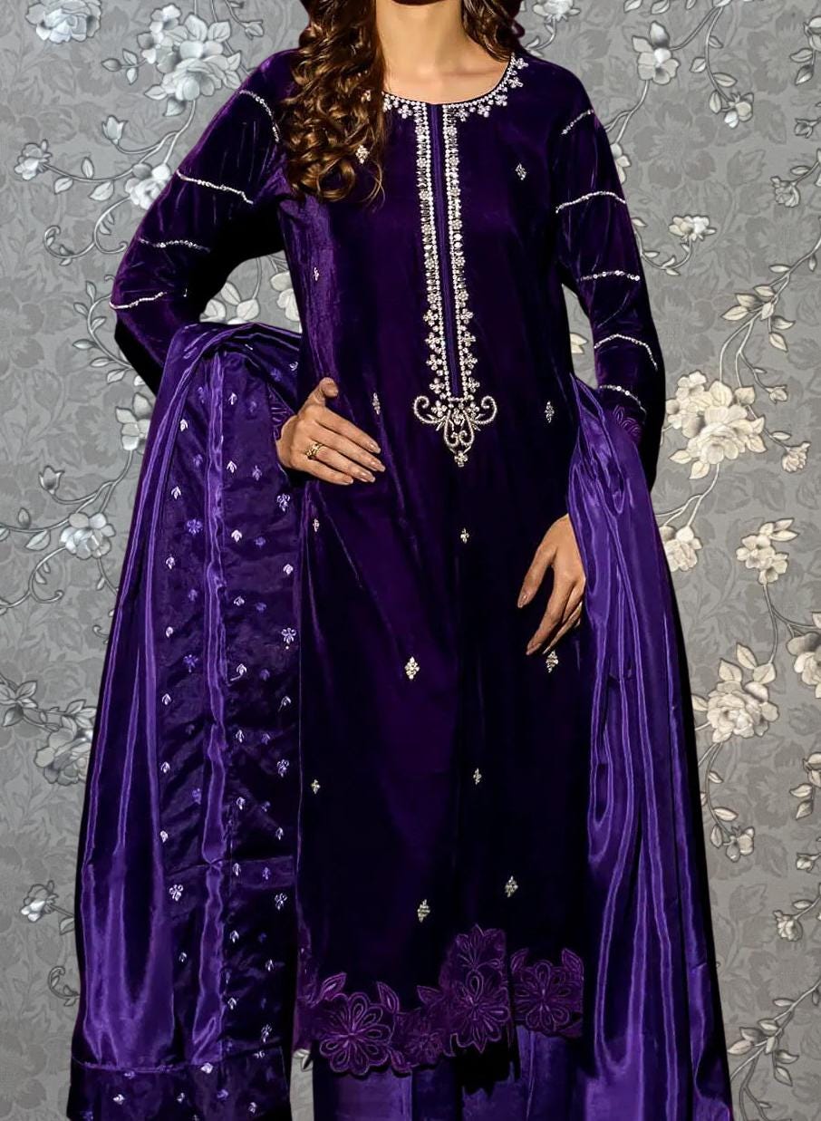 A woman wearing a purple velvet dress with intricate embroidery and a matching purple shawl.