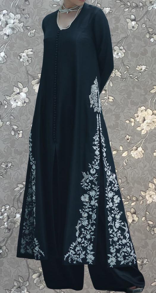 A long, dark blue dress with intricate white floral embroidery on the sleeves and hem.