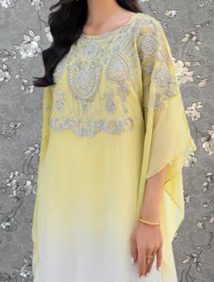 A woman wearing a yellow dress with intricate embroidered designs on the front.