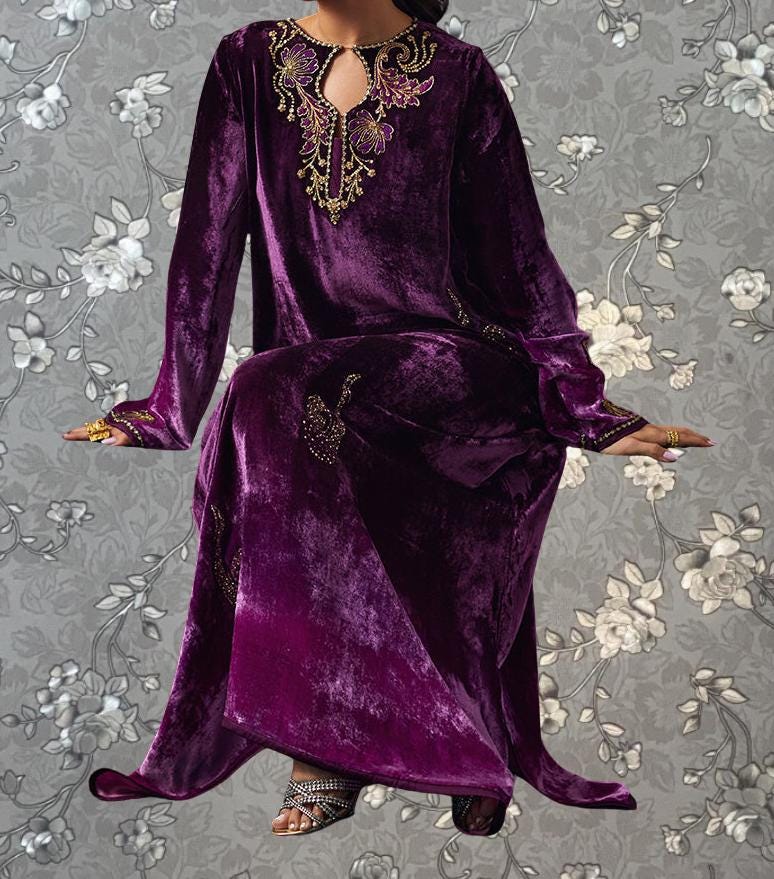A person wearing a long purple velvet dress with gold embroidery and a floral pattern on the background.