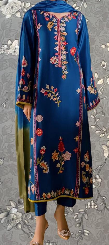A blue and green dress with intricate floral embroidery, featuring a high collar and long sleeves.