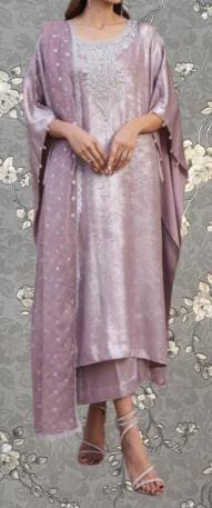 A woman wearing a long, flowing pink dress with a lace-up design and a matching shawl.