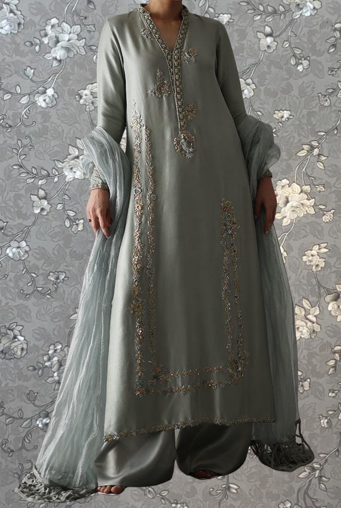 A person wearing a long, gray dress with intricate embroidery and a matching gray shawl.