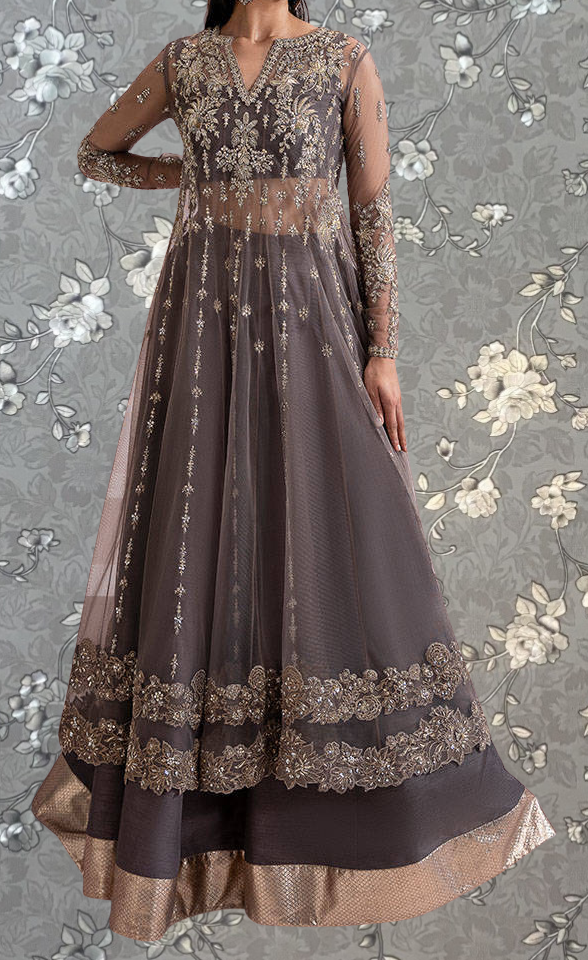 A woman wearing an ornate, gray and gold dress with intricate embroidery and a high collar.
