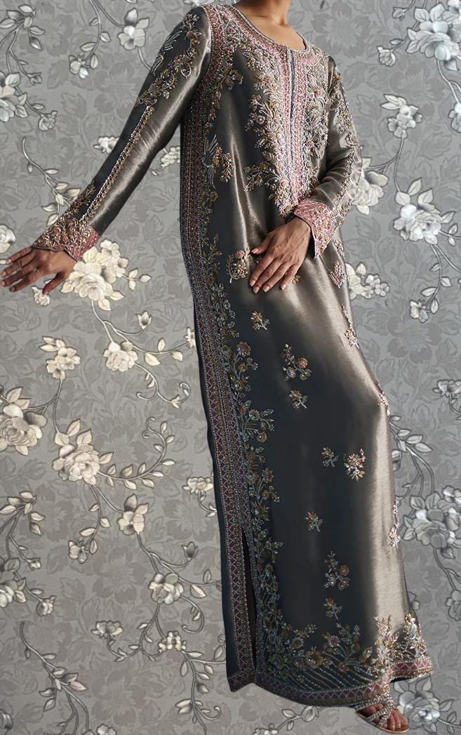 A person wearing a long, gray dress with intricate embroidered patterns and designs.