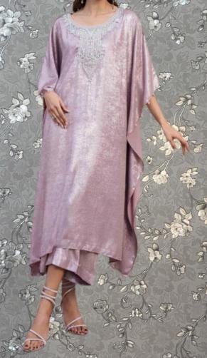 A woman wearing a long, flowing purple dress with a floral pattern on the background.