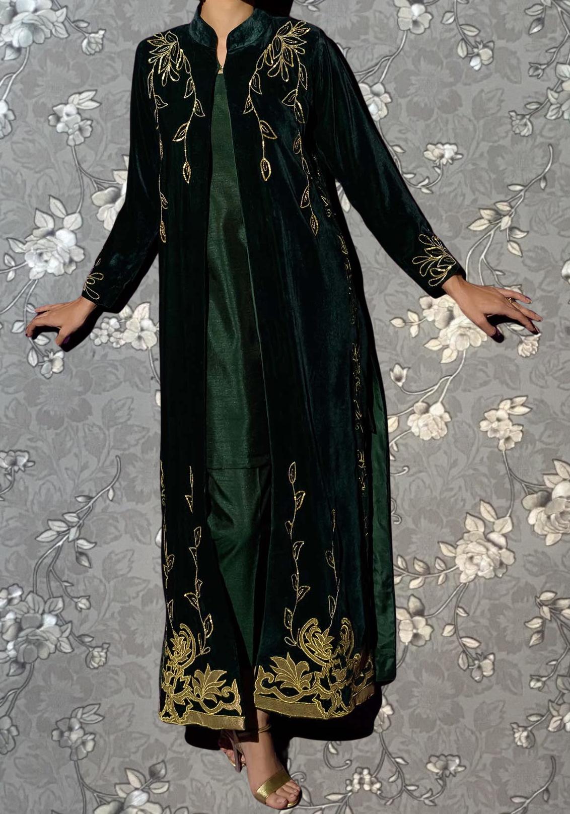 A person wearing a long, green velvet coat with gold embroidered designs on the sleeves and hem.