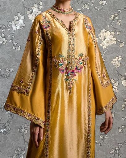 A gold-colored dress with intricate embroidery and floral patterns, featuring a high collar and long sleeves.