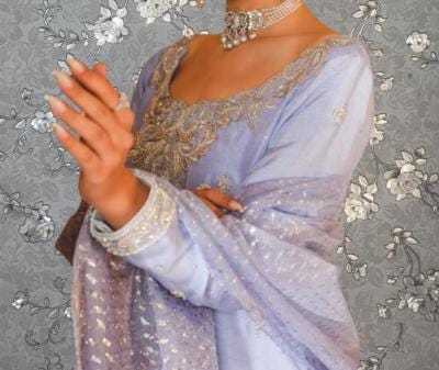 A woman wearing a purple dress with gold embroidery and jewelry poses in front of a gray floral background.