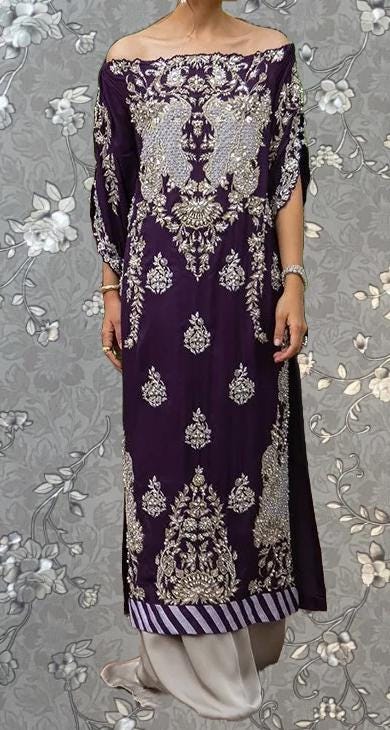 A person wearing a long purple dress with intricate gold embroidery and floral patterns.