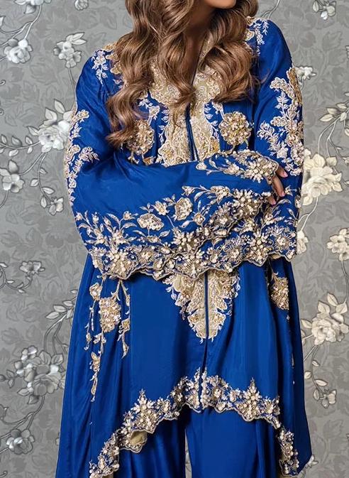 A woman wearing a blue and gold dress with intricate embroidery and floral patterns.