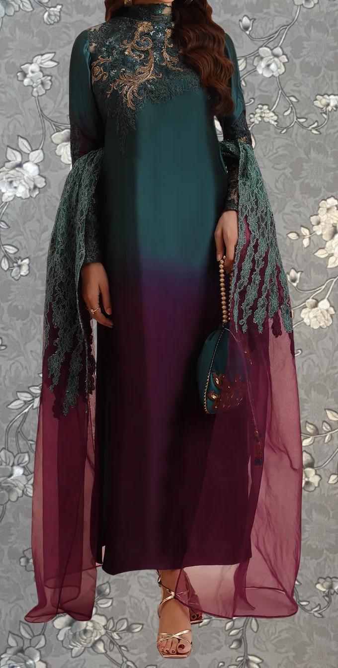 A woman wearing a long, green dress with intricate embroidery and a matching green shawl. She is holding a small purse in her hand.