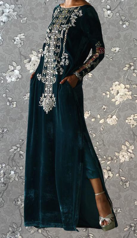 A woman wearing a long, dark green velvet dress with intricate embroidered patterns and designs.