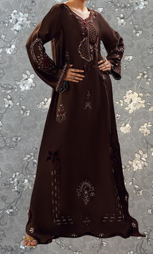 A woman wearing a long, brown dress with intricate embroidery and floral patterns.