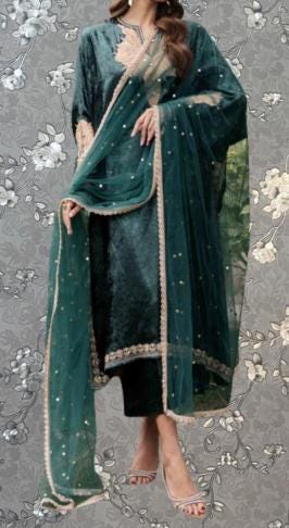 A woman wearing a green velvet dress with gold accents and a matching green shawl.