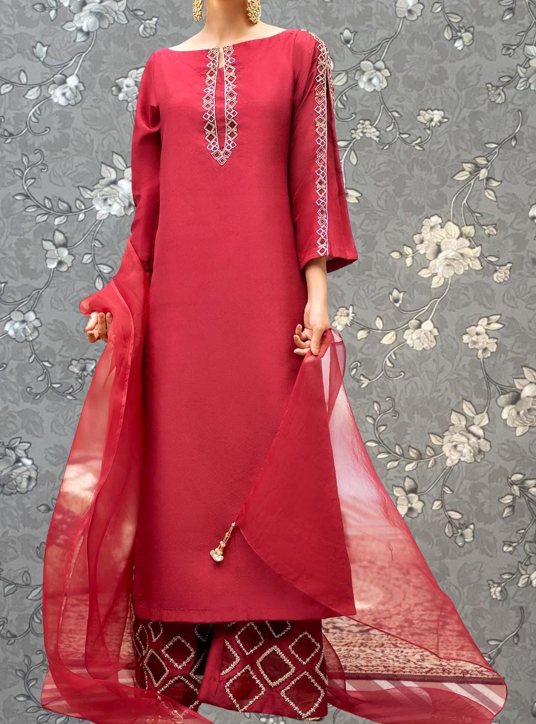 A woman wearing a red dress with a long, flowing skirt and a matching red shawl.